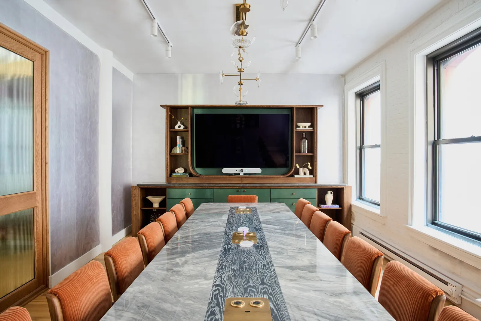 The Malin SoHo Bowery Room — marble conference table, velvet chairs, and conferencing screen