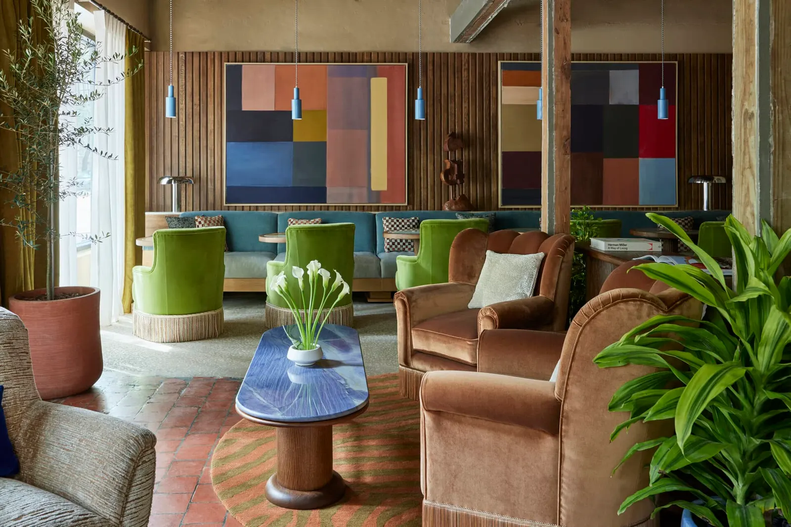 The Malin Savannah — lounge with green armchairs, velvet seating, and color-block artwork